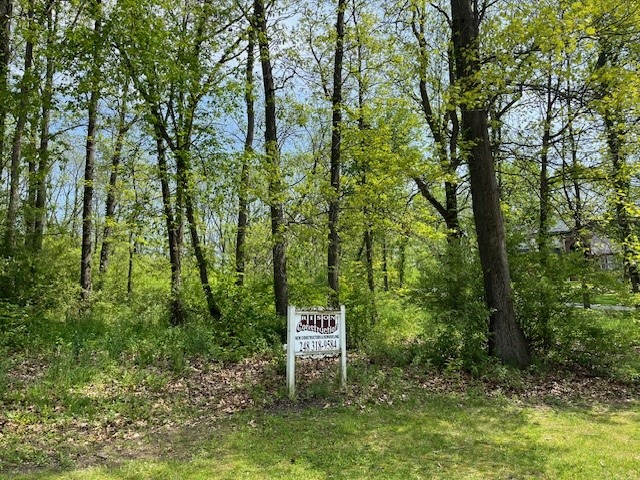 15267 Oak Hollow Drive, Holly MI — wooded one-acre building site with listing sign at the road
