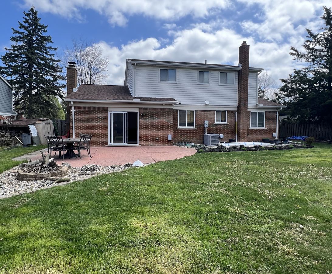 Back of home with stamped concrete patio and outdoor dining