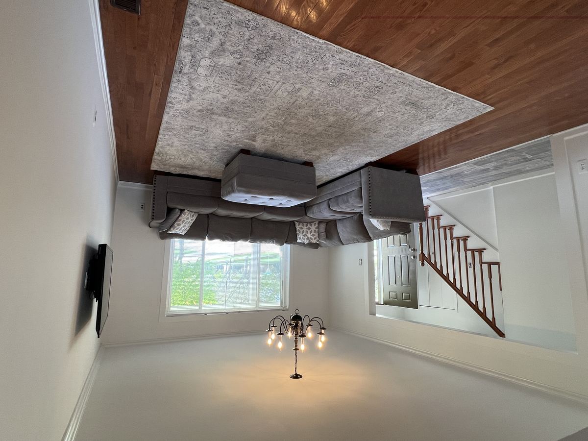 Spacious living room with hardwood floors, chandelier, and open staircase