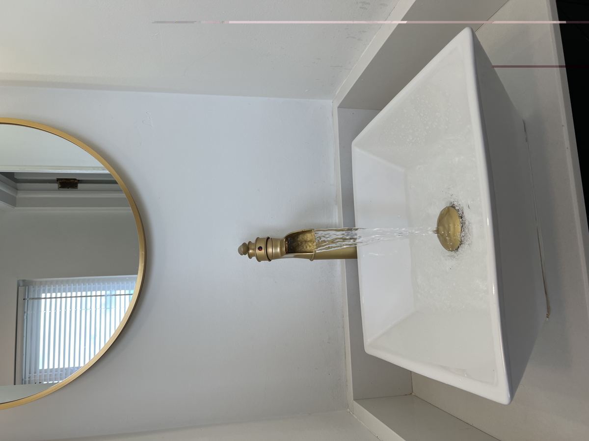 Primary bath — vessel sink with gold waterfall faucet flowing